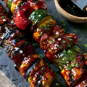 Extreme close-up of grilled zucchini and red peppers with bubbling balsamic glaze. (vegetable kabobs recipe)